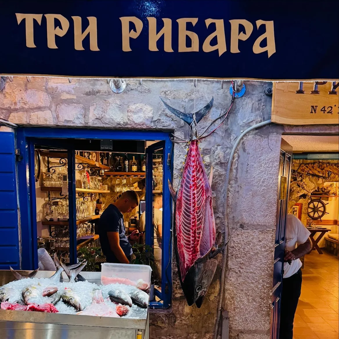 Улаз у ресторан Три Рибара са свежим уловом окаченим испред