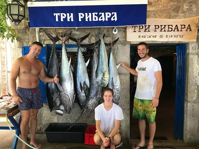 Породица испред ресторана са дневним уловом туне